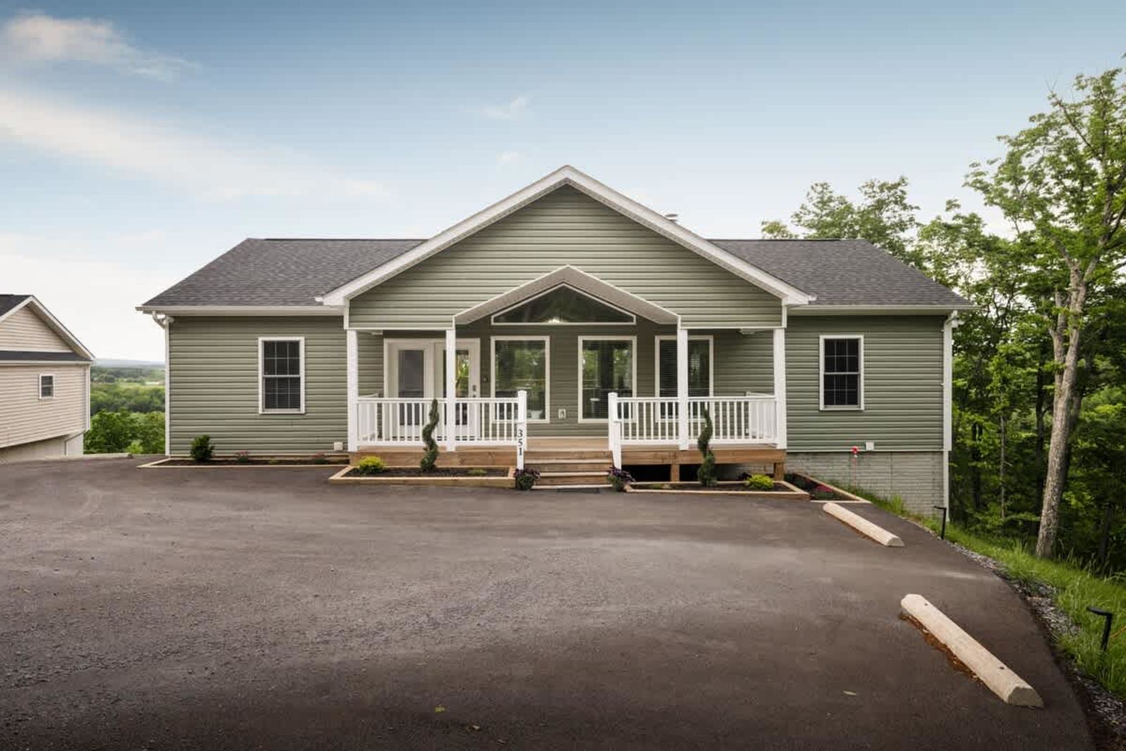 Front of the mountain home with a covered porch and paved drive