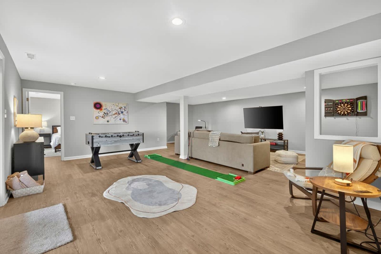 Rec room with foosball, an indoor putting green and a big-screen TV