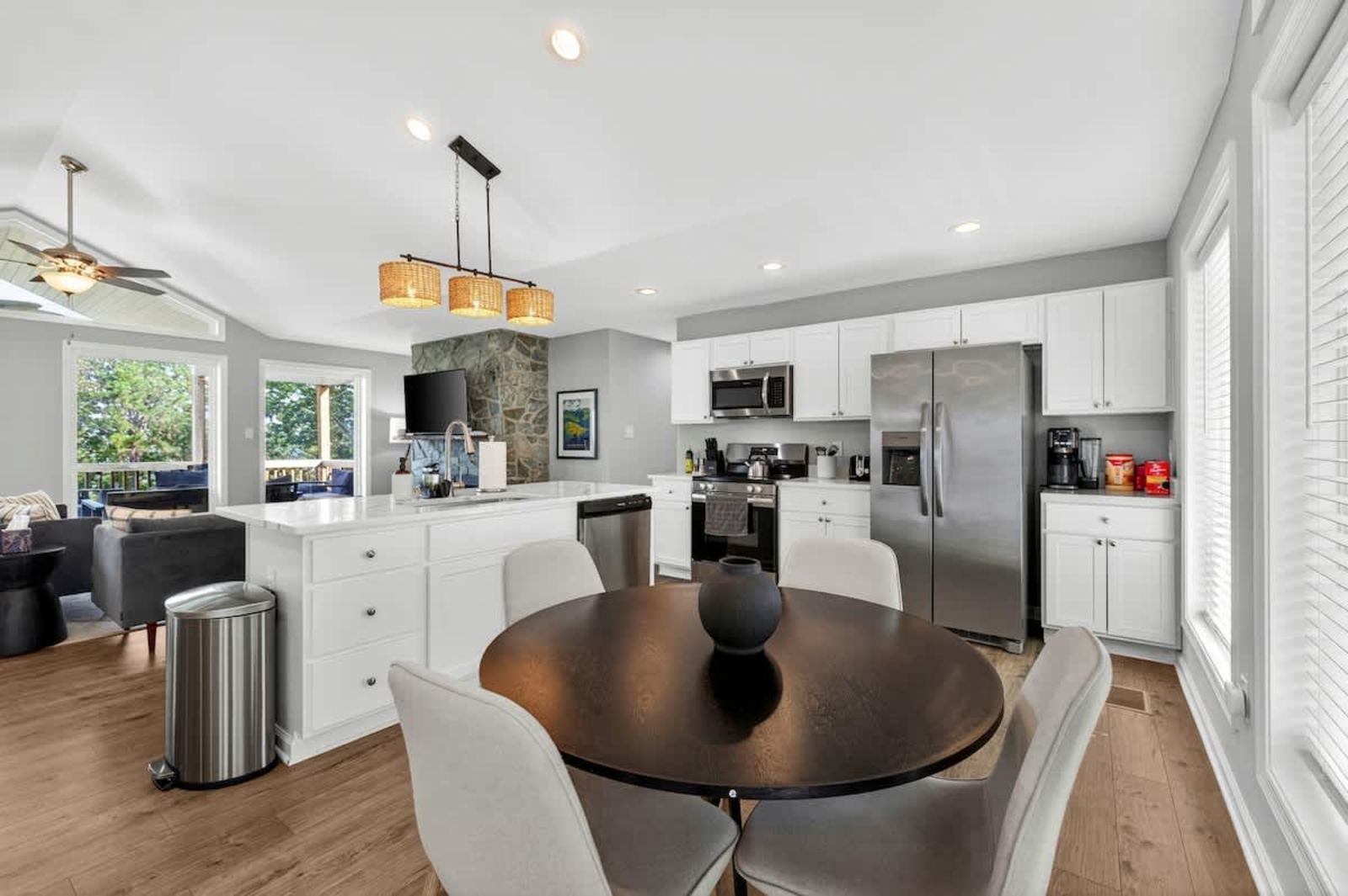 Kitchen with a quartz island, pendant lighting and stone backsplash