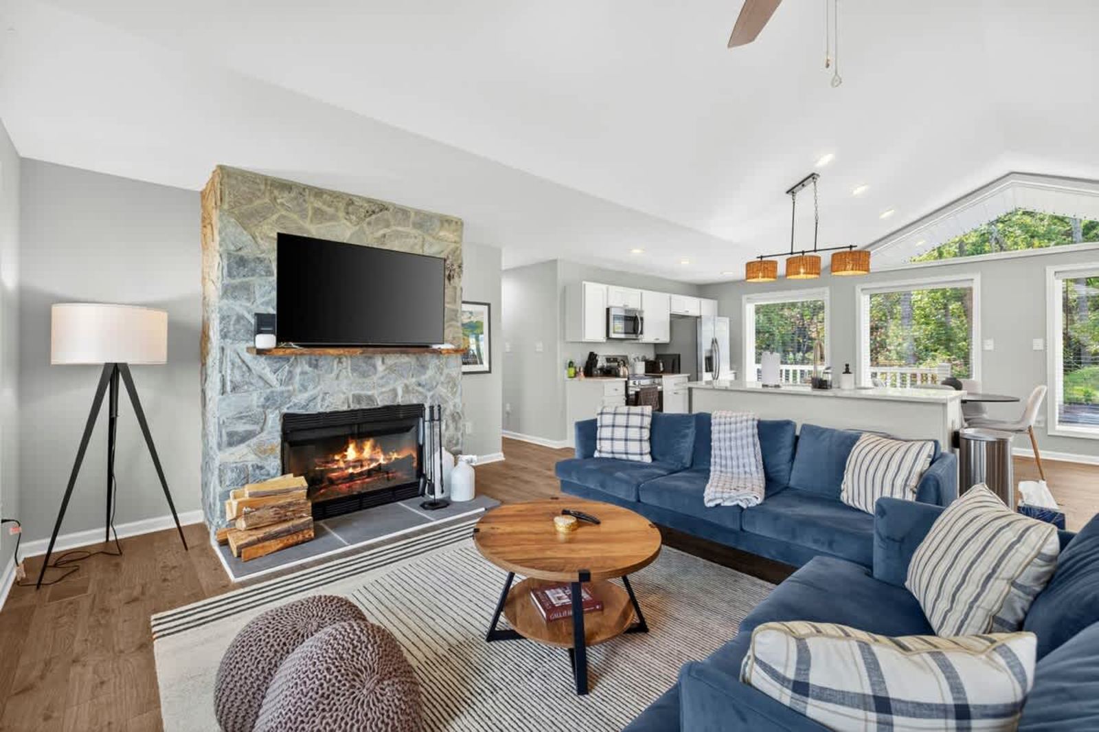 Living room with a stone fireplace, smart TV and sectional sofa